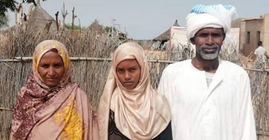 الطالبة النجيبة فاطمة جبريل تتوسط والديها