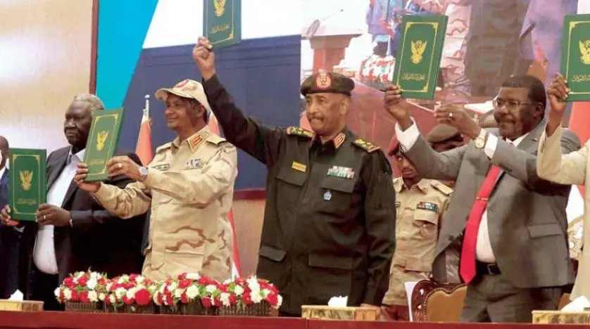 الموقعون على الاتفاقية الإطارية من قادة الجيش والمعارضة المدنية يلوحون بالوثائق في 5 ديسمبر (كانون الأول) 2022 (أ.ف.ب)