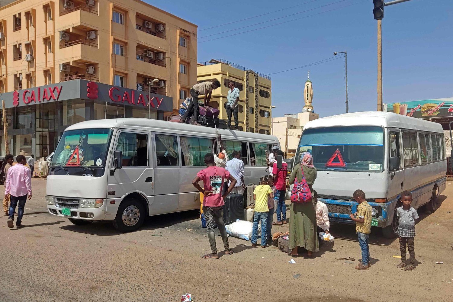 سودانيون يستقلون حافلة لمغادرة جنوب الخرطوم أمس بعد بدء الهدنة (أ.ف.ب)
