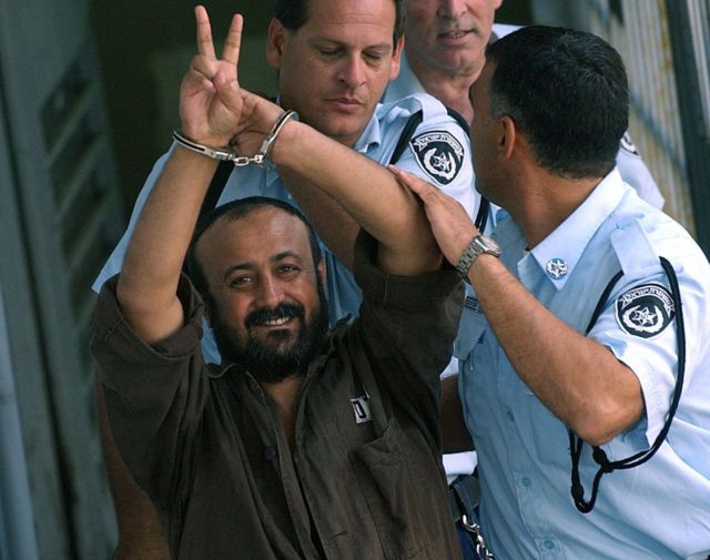 مروان البرغوثي مكبل اليدين ويلوح بعلامة