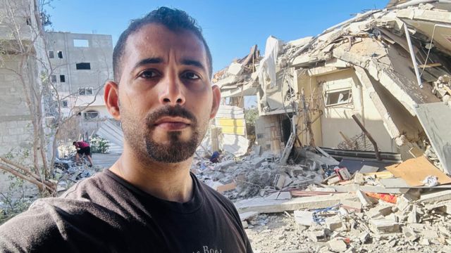 الشاعر الفلسطيني مصعب أبو توهة أمام منزله المهدم في قطاع غزة