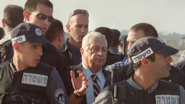 انتفاضة الأقصى اشتعلت يوم 27 سبتمبر/أيلول عام 2001 إثر اقتحام زعيم المعارضة الإسرائيلية أرئيل شارون (وسط الصورة) محاطا بعدد كبير من رجال الأمن الإسرائيليين باحة المسجد الأقصى.
