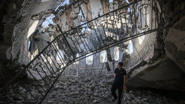 مسجد خالد بن الوليد المدمر من الداخل. رجل يراقب الضرر من داخل القبة