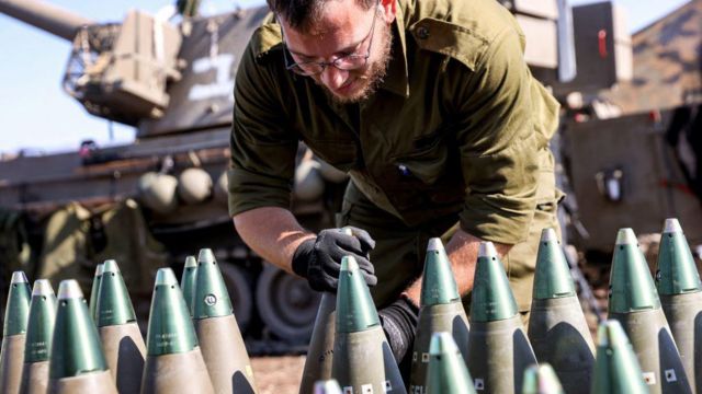 جندي إسرائيلي يضبط رأس قذيفة مدفعية عيار 155مم بالقرب من الحدود مع لبنان
