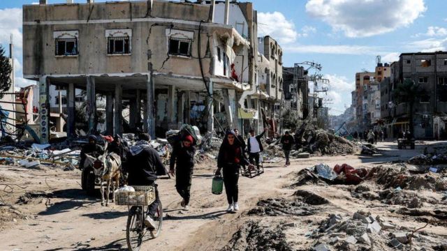 صورة تظهر فلسطينيين في أحد الأحياء المدمرة في قطاع غزة