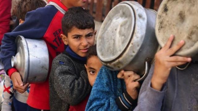 أطفال يصطفون للحصول على الغذاء في رفح، بالقرب من حدود غزة مع مصر