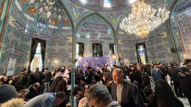 مُصوِّتون يتجمعون داخل حُسينيّة إرشاد، المستخدمة كمركز اقتراع في شرق طهران