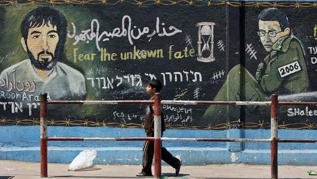 جدارية في مخيم جباليا في غزة عام 2010 يظهر فيها رون آراد إلى جانب الجندي جلعاد شاليط الذي كان محتجزاً لدى حماس