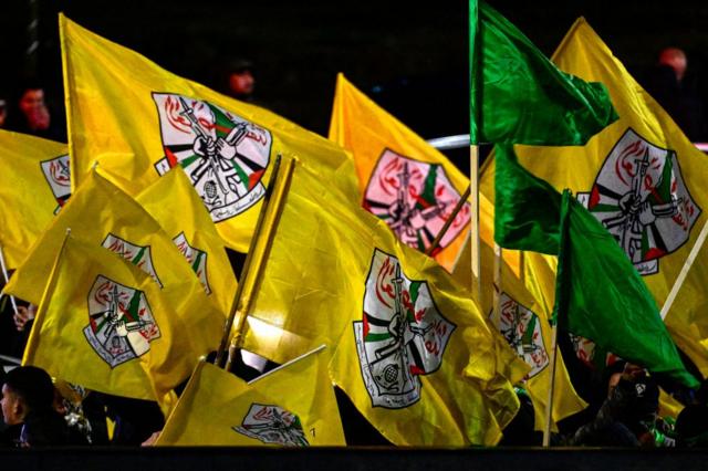 فلسطينيون يلوحون بالأعلام الصفراء لحركة فتح أثناء انتظار إطلاق سراح السجناء مقابل الرهائن الإسرائيليين الذين تحتجزهم حماس، في رام الله بالضفة الغربية المحتلة في 27 نوفمبر/تشرين الثاني 2023.