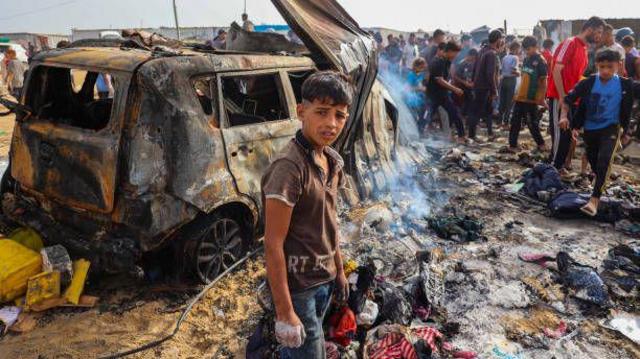 فلسطينيون تجمهروا عند المكان الذي تعرض للقصف الإسرائيلي في مخيم للنازحين في رفح