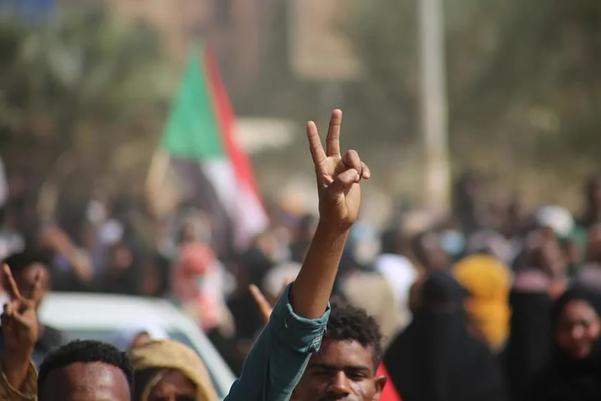 متظاهرون مؤيدون للديمقراطية يرفعون إشارة النصر بعدما نزلوا إلى الطرقات لإدانة استيلاء ضباط الجيش على السلطة، في الخرطوم، في 25 أكتوبر/تشرين الأول 2021. ©2021 "آيه بي"