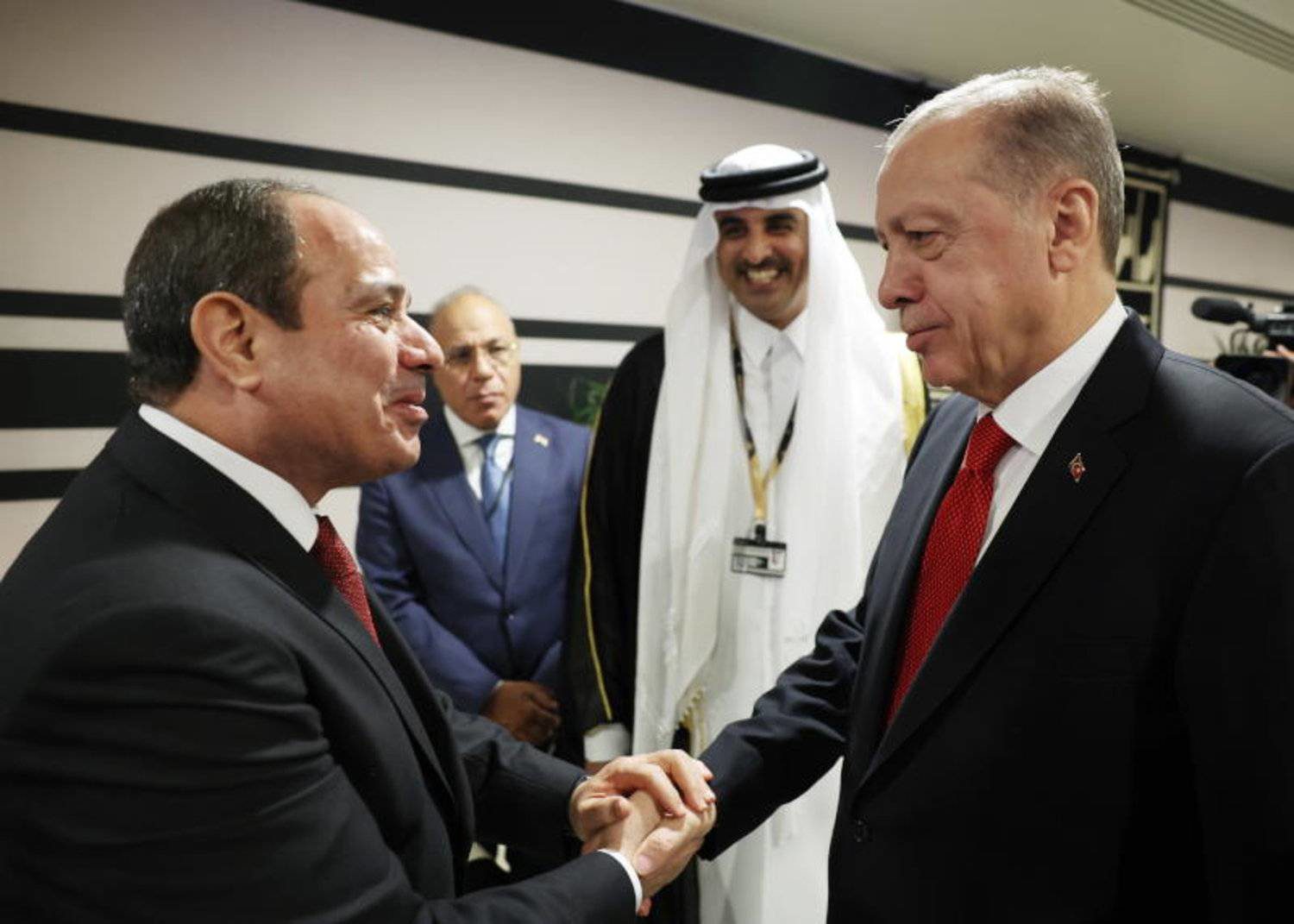 مصافحة إردوغان والسيسي بحضور أمير قطر على هامش افتتاح المونديال (إ.ب.أ)