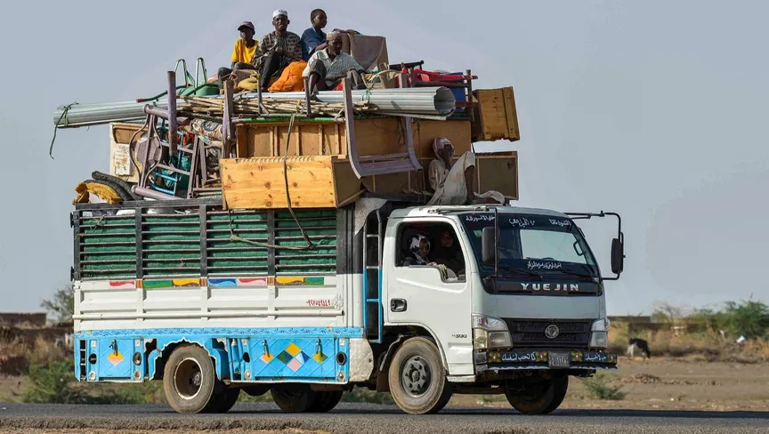 سودانيون على متن شاحنة محملة بالأثاث على الطريق الرابطة بين الخرطوم وواد مدني، السودان. 22 نوفمبر 2023. - AFP