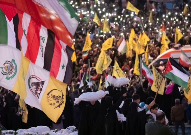 نساء محجبات يعانقن طرودًا ملفوفة بالأكفان، ترمز إلى أجساد الأطفال الفلسطينيين خلال مظاهرة مناهضة لإسرائيل في طهران