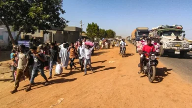 سودانيون نازحون يحملون أمتعتهم على طول طريق بمدينة ود مدني عاصمة ولاية الجزيرة في السودان. 16 ديسمبر 2023 - AFP