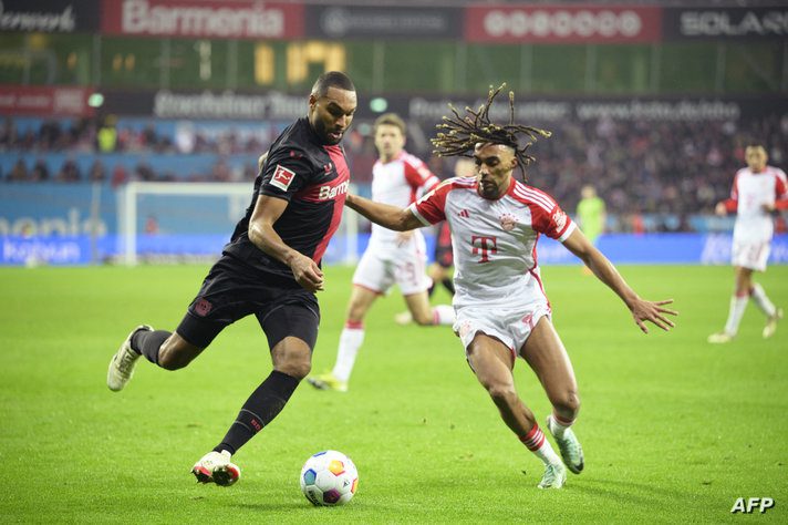Bayer Leverkusen's German defender #04 Jonathan Tah (L) and Bayern Munich's French defender #20 Bouna Sarr (R) vie for the ball…