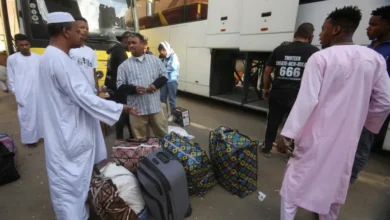 لاجئون سودانيون ينتظرون بجوار أمتعتهم في نقطة تجمع للحافلات بالقاهرة في طريق عودتهم الطوعية من مصر إلى السودان. 11 أبريل 2025 - REUTERS