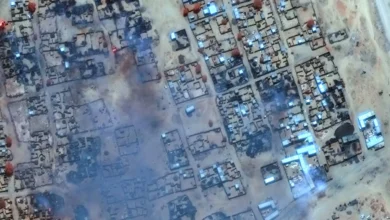 صورة جوية تظهر تصاعد الدخان من المباني المحترقة في مخيم زمزم قرب مدينة الفاشر في دارفور (أرشيفية - أ.ف.ب)